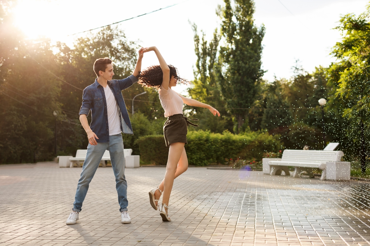 teen couple dancing in park