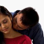 husband kissing woman on neck
